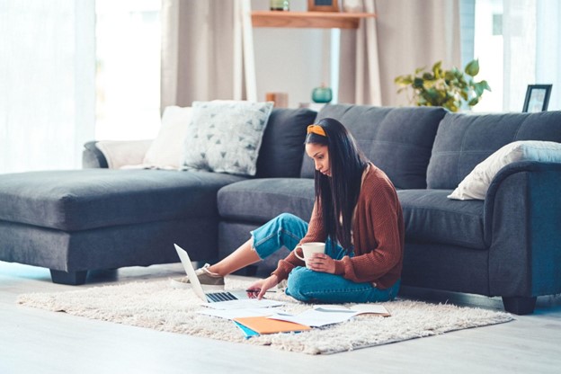 A young woman with long, dark hair examines lender credit information on her laptop.